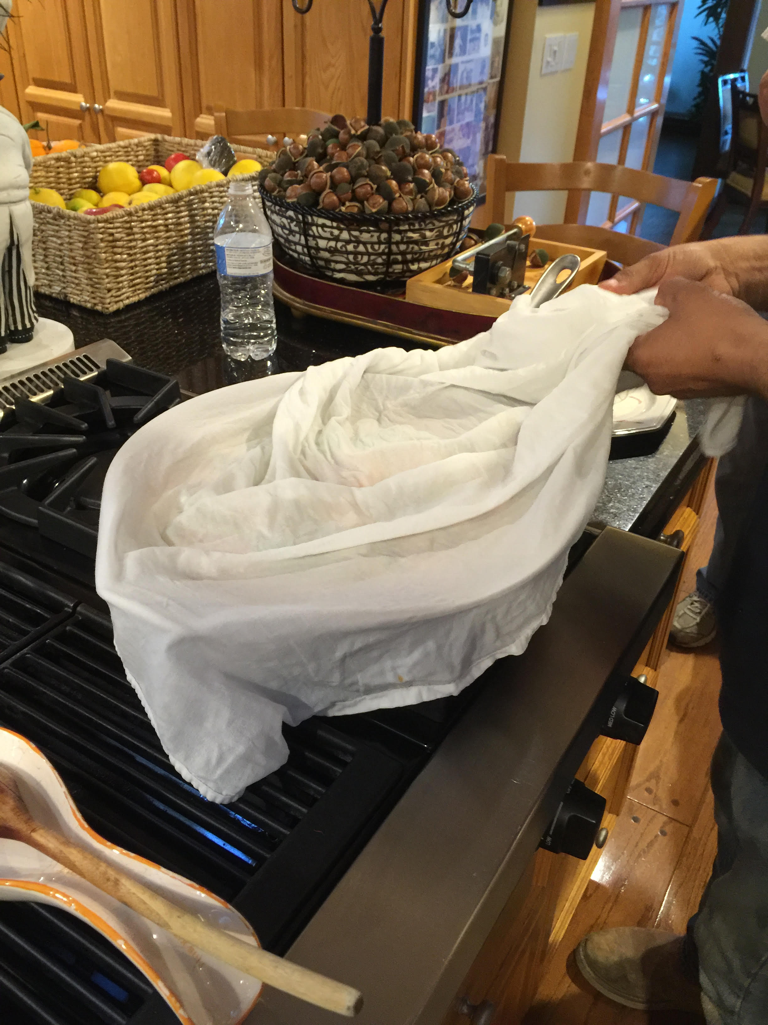 Wrapping cheesecloth around paella pan before putting on the lid